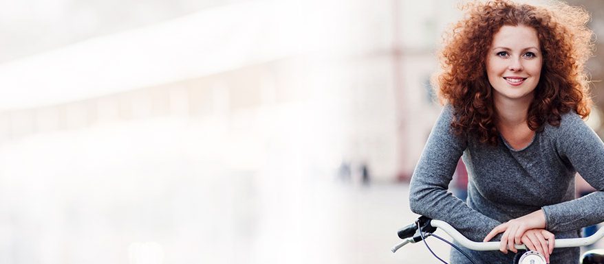 mulher apoiada em uma bicicleta